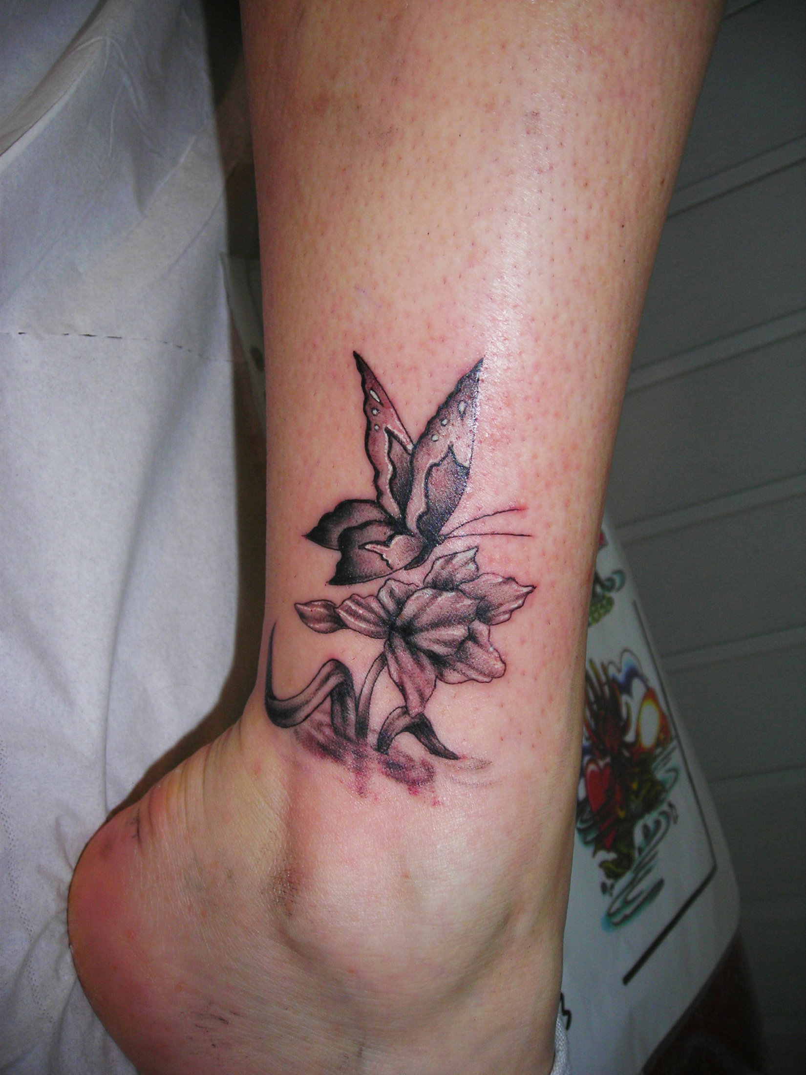 Tatouage fleur et papillon sur la cheville - Tattoo Studio