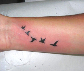 Tatouage envolée d'oiseaux sur le poignet. Tatouage discret et élégant.
