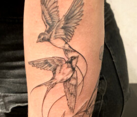Tatouage d'oiseaux hirondelles avec des traits très fins et délicats de style "Finework"