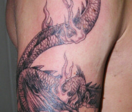 Tatouage dragon en haut du bras style réaliste