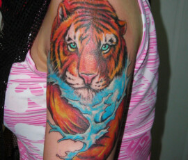 Tatouage d'un tigre sur le bras en couleur style réaliste.