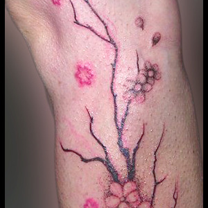 Tatouage cerisier en fleur sur la jambe