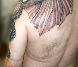 Tatouage de dragon couvrant l'épaule, l'omoplate et le pectoral