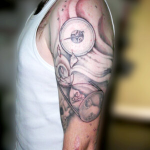 Tatouage sablier en noir et ombre, symbolisant le temps qui passe.