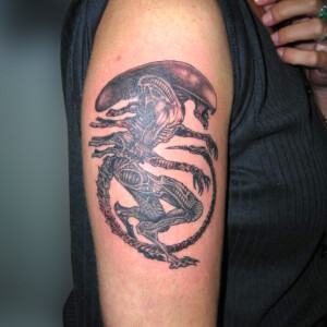 Tatouage alien en style réaliste sur le bras