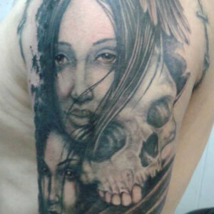 Tatouage composition visages et têtes de mort sur le bras