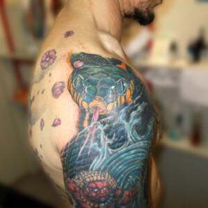 Tatouage en couleur serpent sur l'épaule et le bras