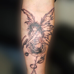 Tatouage fée dans une fleur en noir et ombre style réaliste