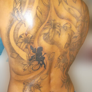 Tatouage fleur et fée dans le dos en noir et dégradés
