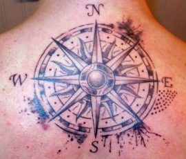 Tatouage boussole en haut du dos