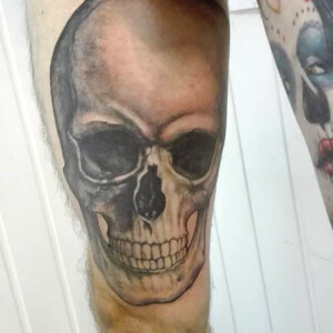 Tatouage tête de mort sur la cuisse gauche