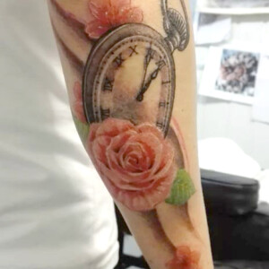 Tatouage montre et roses sur l'avant-bras