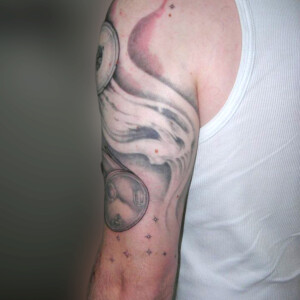 Tatouage sablier en noir et ombre, symbolisant le temps qui passe.