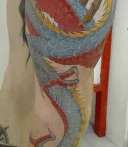 Tatouage d'un dragon couleur s'enroulant autour de la jambe