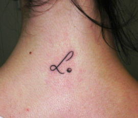 Tatouage discret initiale sur la nuque