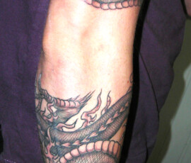 Tatouage de dragon asiatique s'enroulant autour du bras