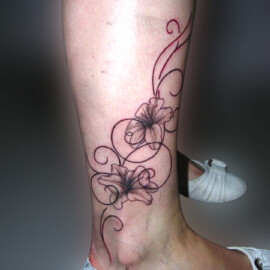 Tatouage fleur et arabesque sur le pied