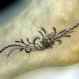 Tatouage fleur et arabesque sur le pied