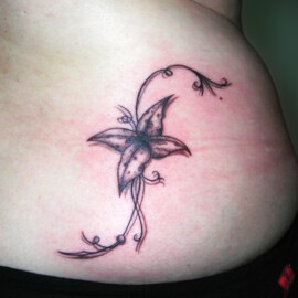 Tatouage fleur et arabesque dans le bas du dos