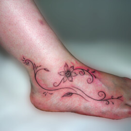 Tatouage fleur et arabesque sur le pied