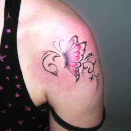 Tatouage papillon et arabesque sur l'épaule